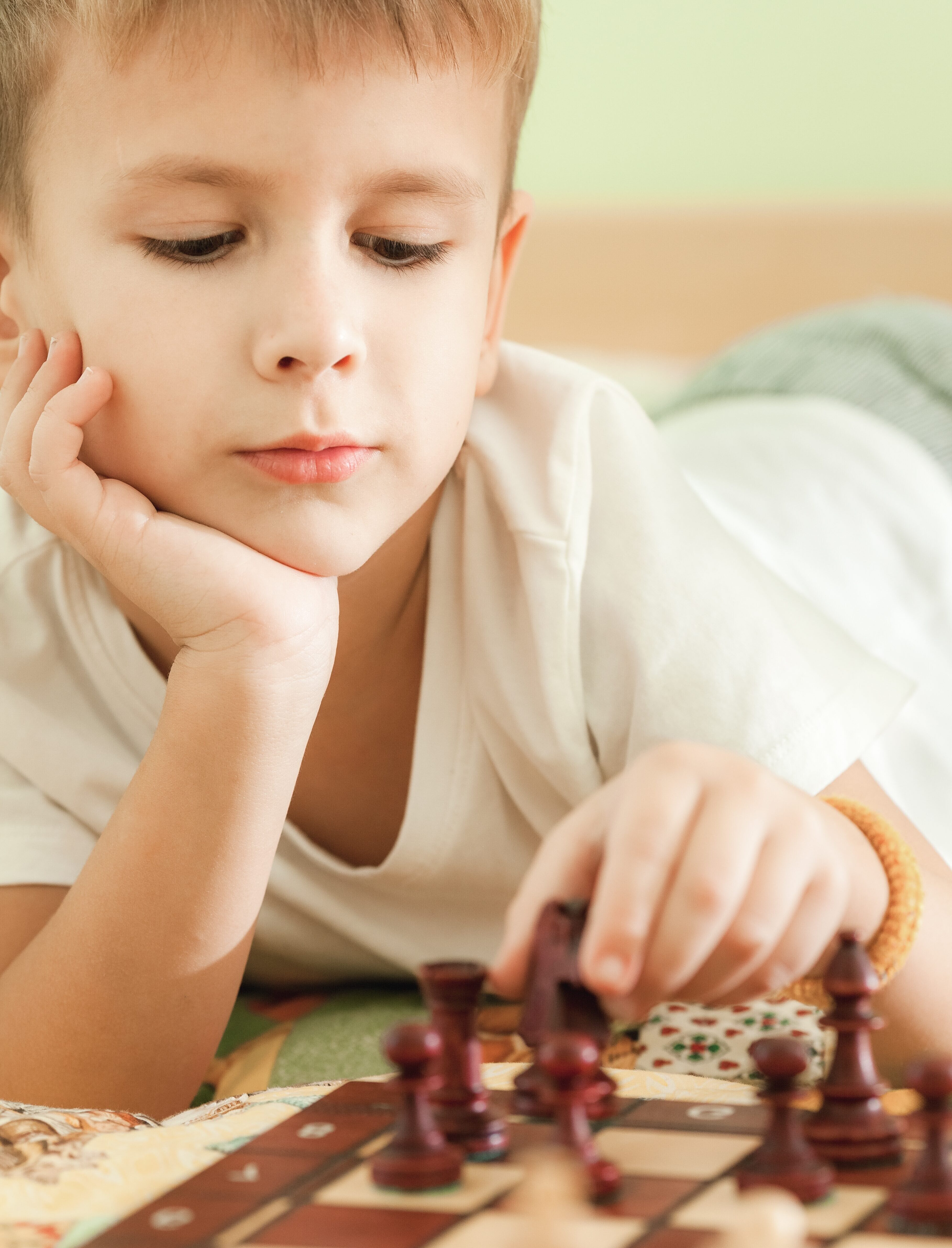 Little boy plays chess. Figures on a chessboard. Game of chess.
