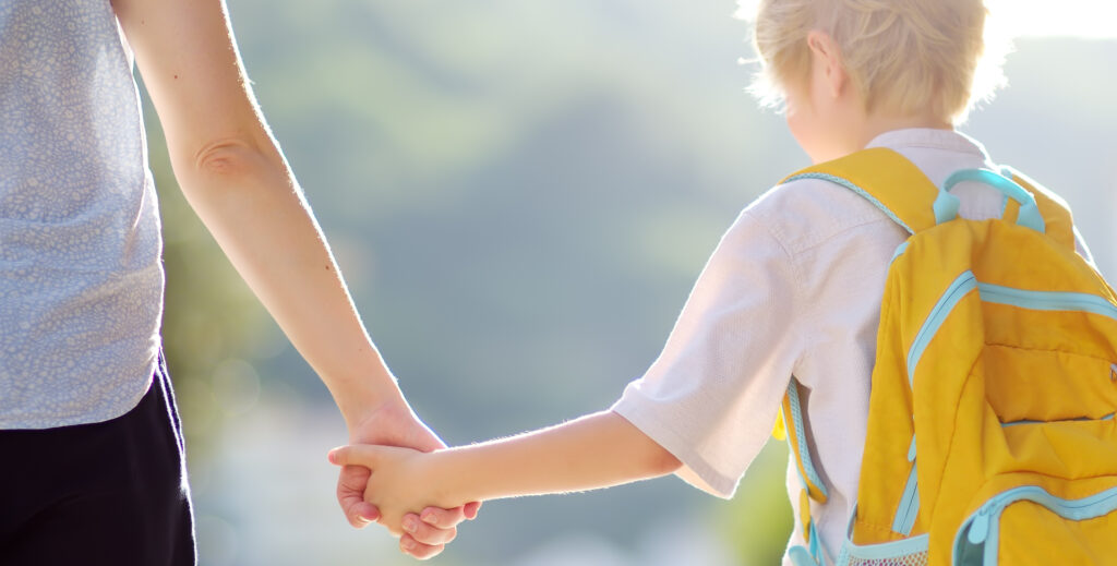 Little schoolboy with his mother goes to school after summer holiday